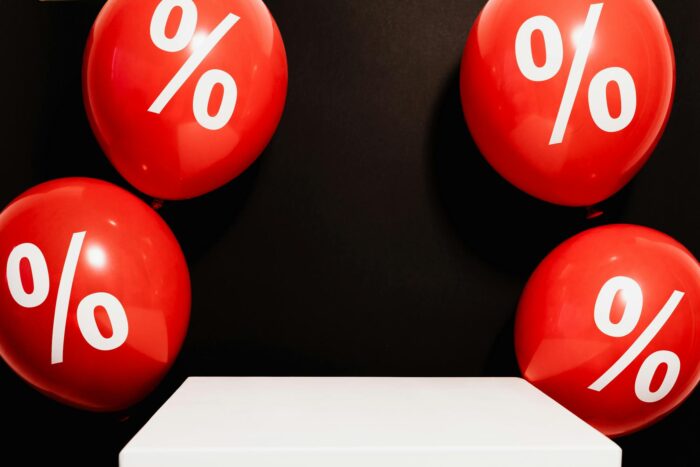 Red balloons marked with percentage symbols on black background, perfect for sales promotions.